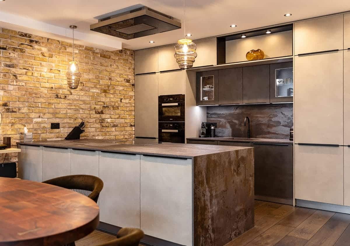 Ebstone handleless kitchen with concrete and rust effect cabinetry, exposed London brick wall and amber glass pendant lights