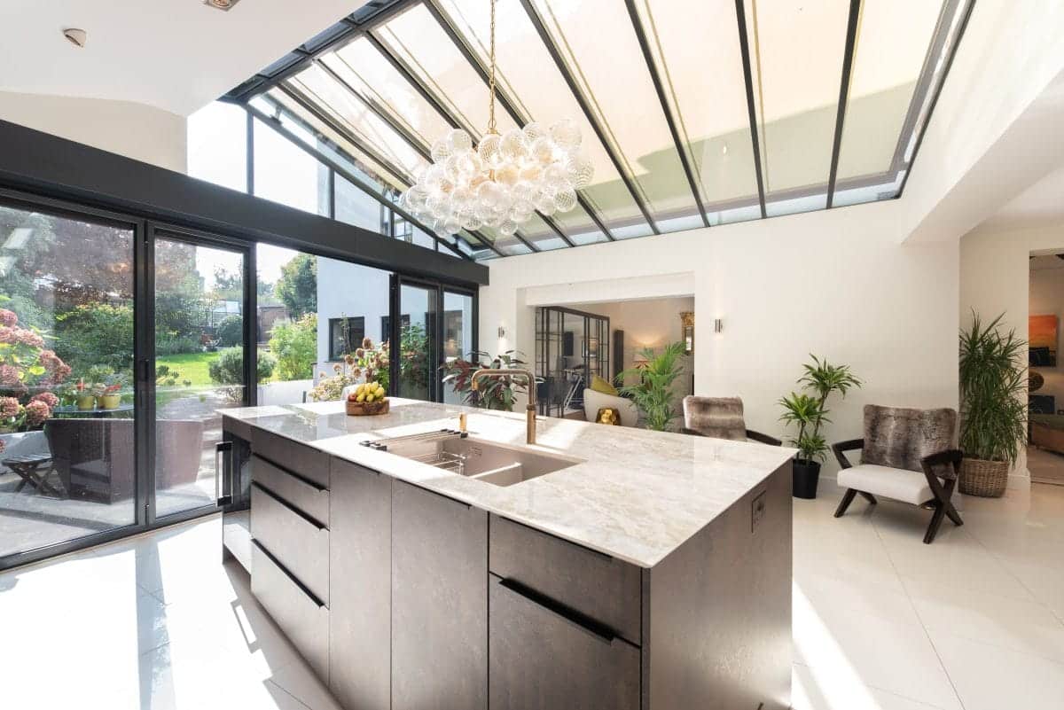 Luxury open plan kitchen extension with stone worktops, large island, roof lantern and garden views