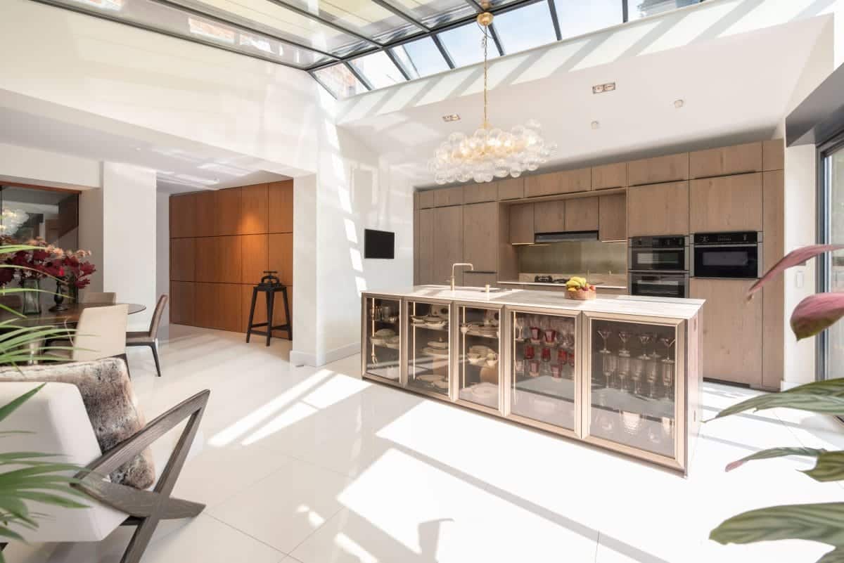 Ebstone natural oak kitchen with brass-framed glass display island, bubble glass chandelier and full-width rooflight lantern