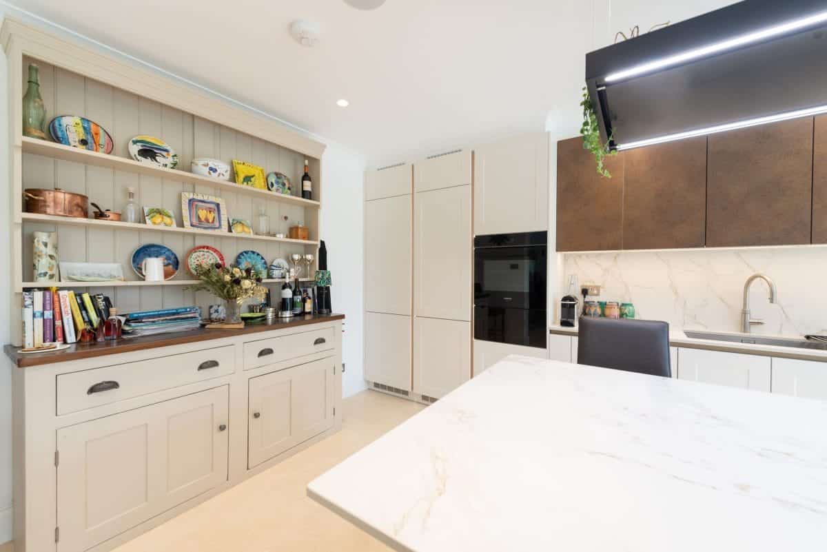 Bespoke kitchen combining traditional display cabinetry with modern units and a stone island.