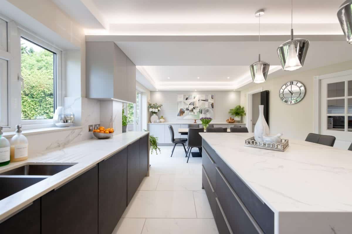 Open-plan handleless kitchen with integrated appliances, island worktop and dining area