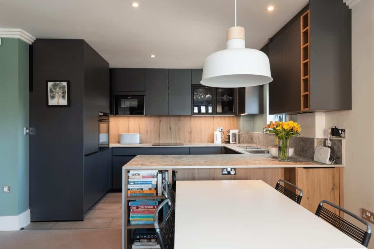 Modern dark and wood kitchen with solid wood worktops, open shelving and dining area