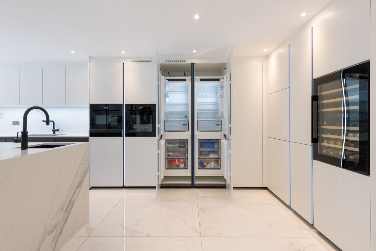 Contemporary white kitchen with integrated appliances, tall fridge freezers and built-in wine cooler