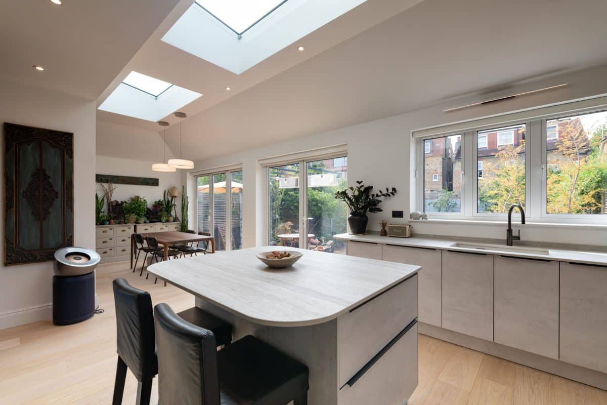Light open-plan kitchen with rounded island, bar seating and overhead skylights
