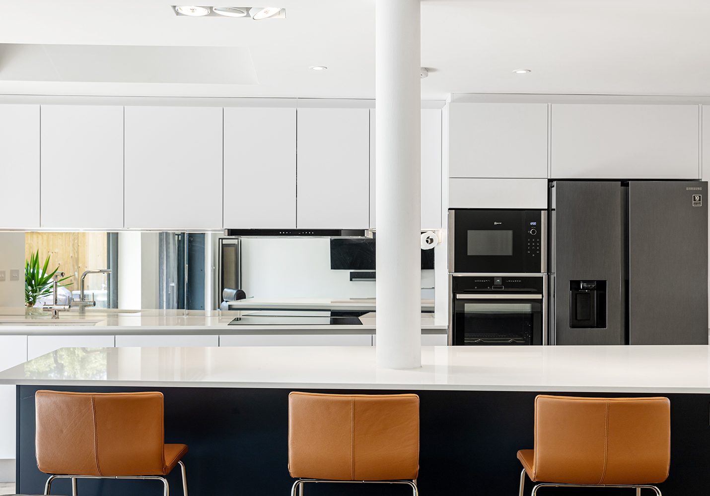 Ebstones Kitchens -White Handleless Kitchen with dark island and mirrored splashback White Handleless Kitchen with dark island and mirrored splashback